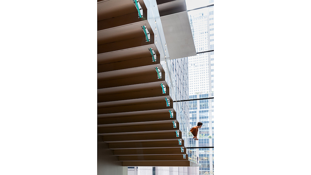 A group of people walking on a sidewalk between tall buildings.